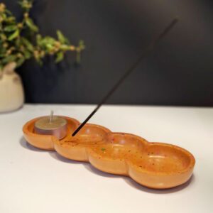 Ppodstawka pod kadzidełka z gipsu polimerowego wykonana metodą lastryko o podłużnym kształcie z wkładem tealight i kadzidełkiem.